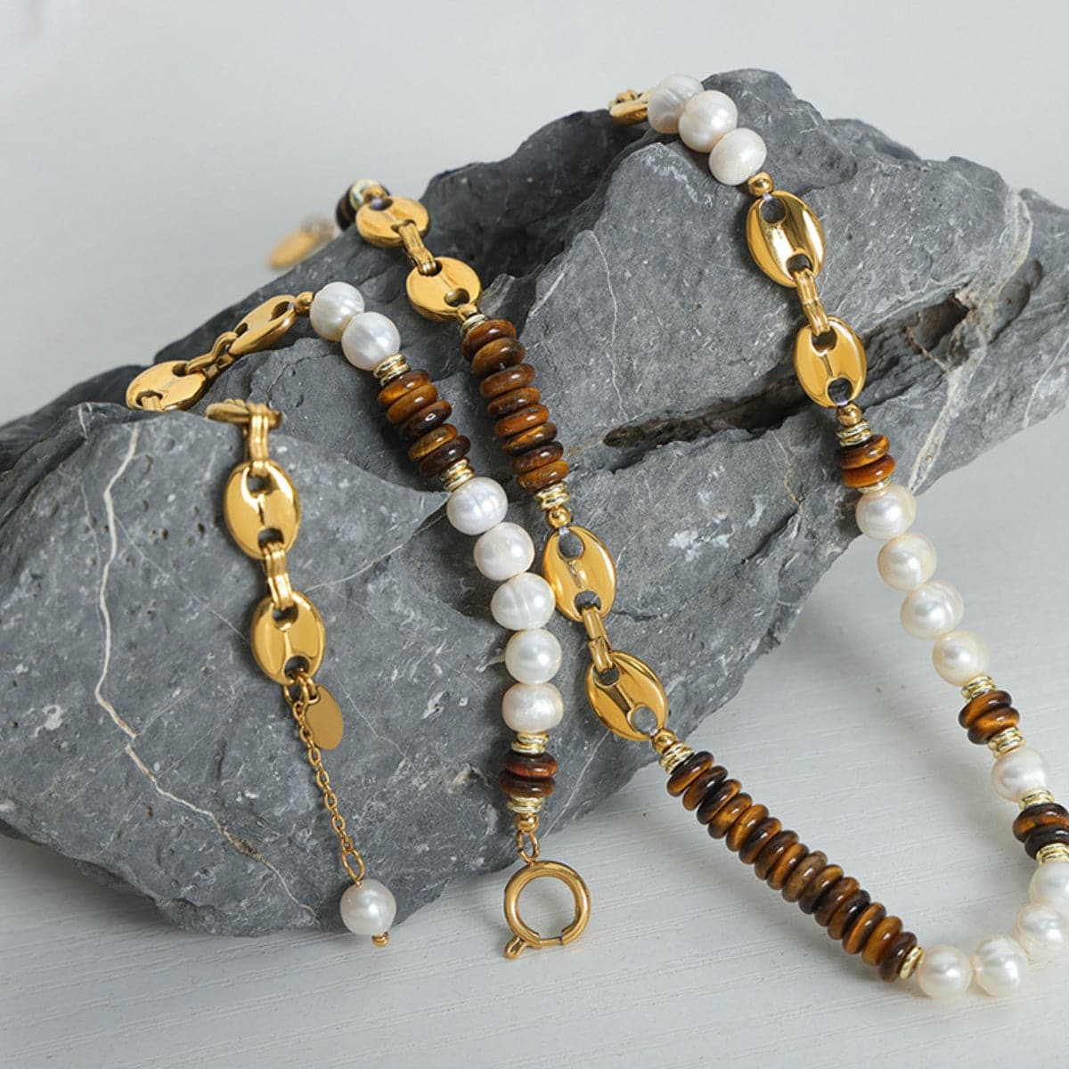 Elegante armband van titaniumstaal met 18K vergulding en parel